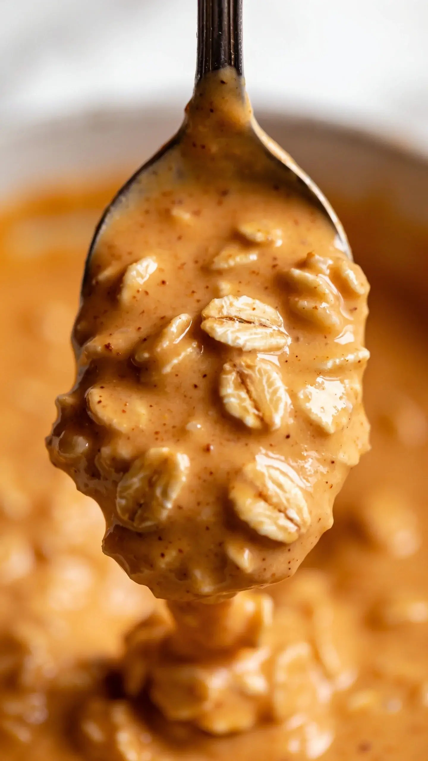 Spoonful of thick pumpkin pie overnight oats above the jar