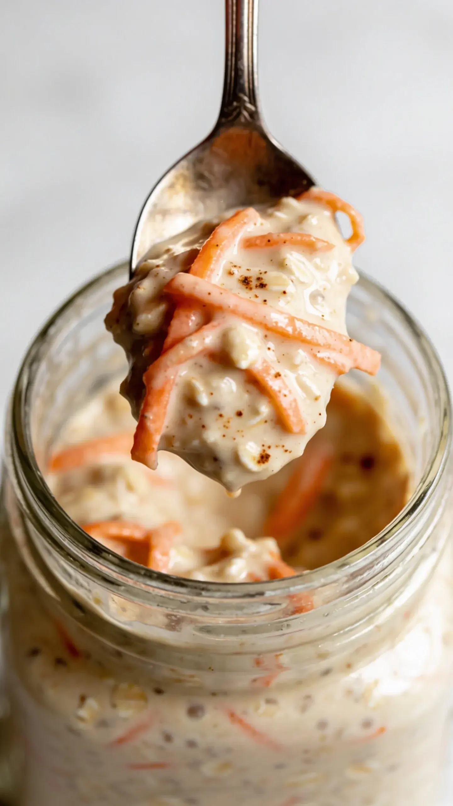 Spoonful of carrot cake overnight oats above the jar