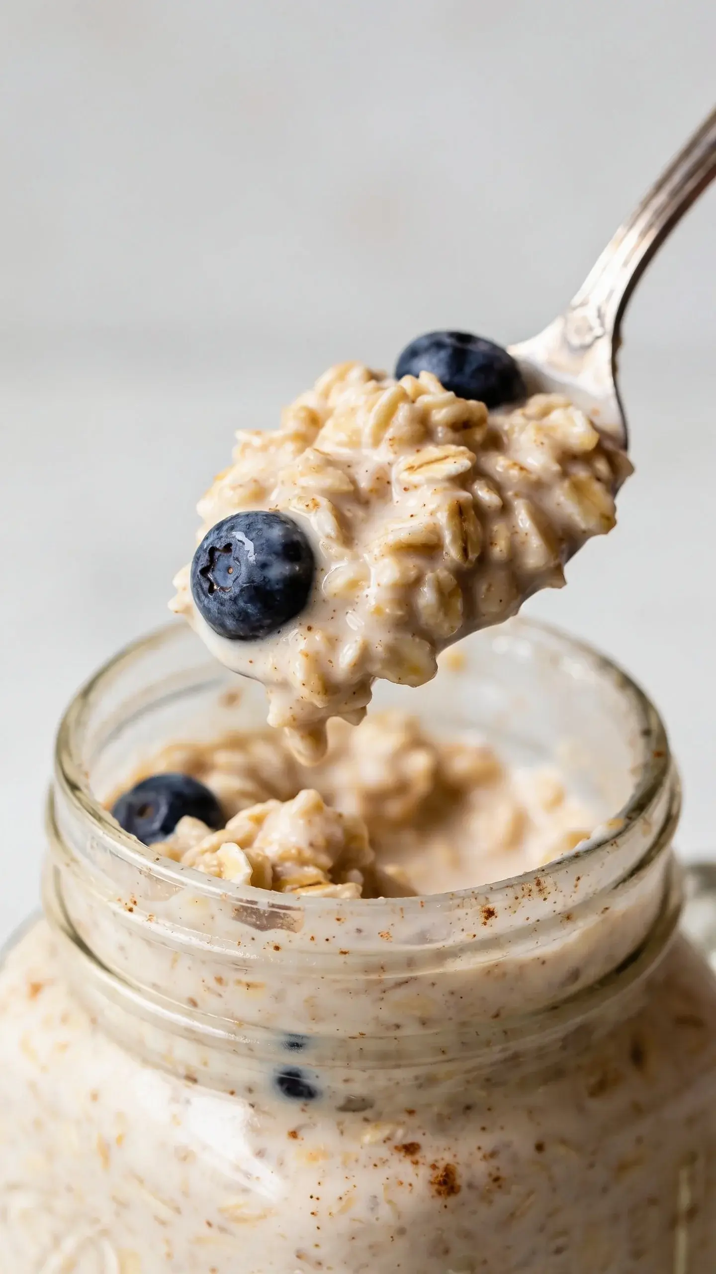 Spoonful of blueberry muffin overnight oats above the jar